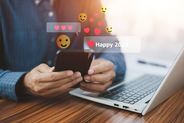 Las personas que usan un teléfono inteligente móvil enviaron un mensaje feliz 2023 por concepto de feliz año nuevo