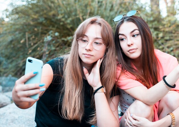 Personas que usan teléfonos inteligentes al aire libre - amigos tomando fotos