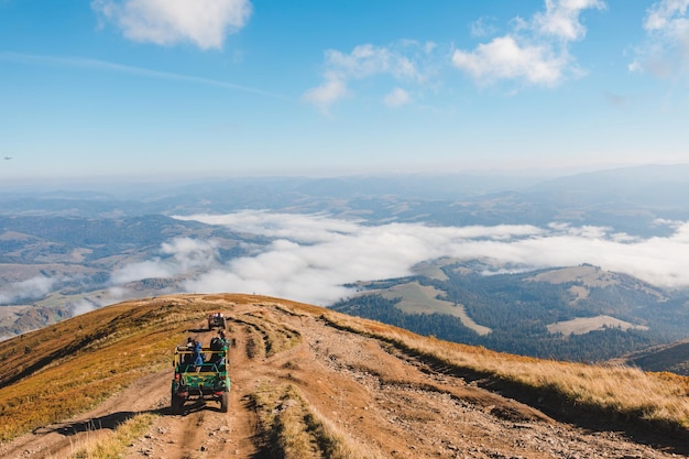 Personas que viajan en autos todoterreno en el pico de la montaña