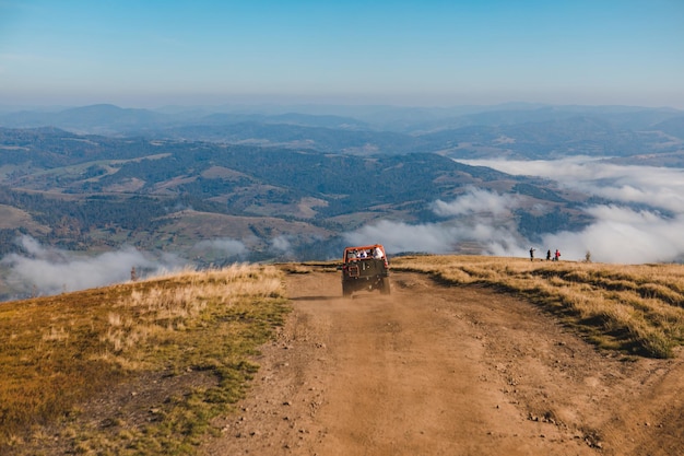 Personas que viajan en autos todoterreno en el pico de la montaña