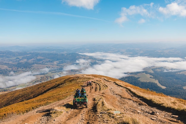 Personas que viajan en autos todoterreno en el pico de la montaña