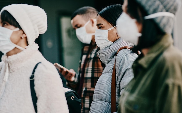 Personas que viajan con mascarilla en una pandemia de covid en la multitud pública o en la frontera del aeropuerto con pasaporte o restricciones de viaje Extranjeros que usan protección para prevenir la propagación de enfermedades en el extranjero