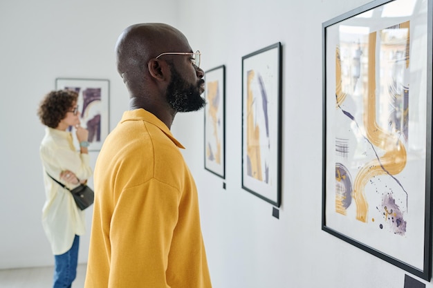 Personas que visitan la exposición de arte en la galería.