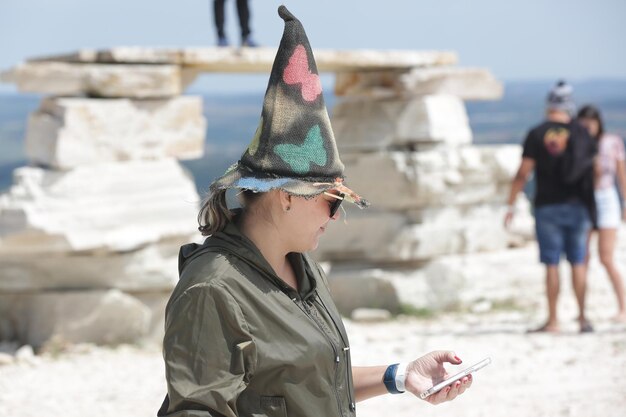 Personas con sombreros de brujas en un viaje a un logoa secreto entre las rocas y cascadas en la montaña