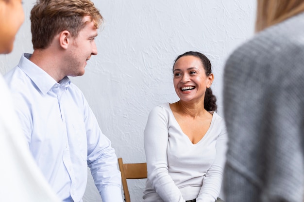 Foto personas sonrientes juntas en una sesión de terapia de grupo