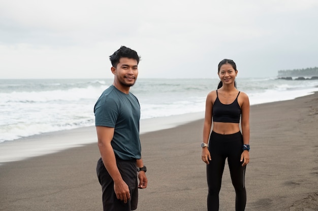 Personas sonrientes de tiro medio en la playa