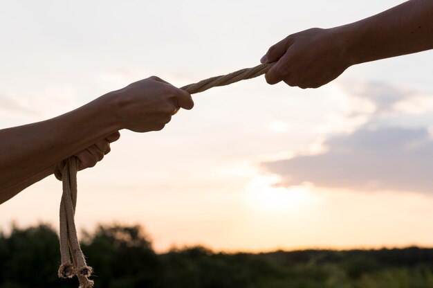 Foto personas sosteniendo una cuerda apretada con espacio de copia