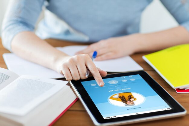personas, tecnología y concepto de medios: cierre de una estudiante con una aplicación de reproductor de música en una computadora de tablet pc y una computadora portátil en casa