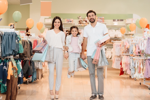 Personas en la tienda de ropa del centro comercial. La niña está saltando.