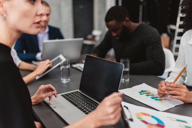 Las personas trabajan juntas como trabajo en equipo y se asocian con gráficos de negocios