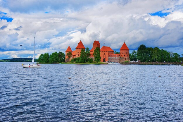 Personas en veleros en el lago Galve y el museo del castillo de la isla de Trakai durante el día, cerca de Vilnius, Lituania