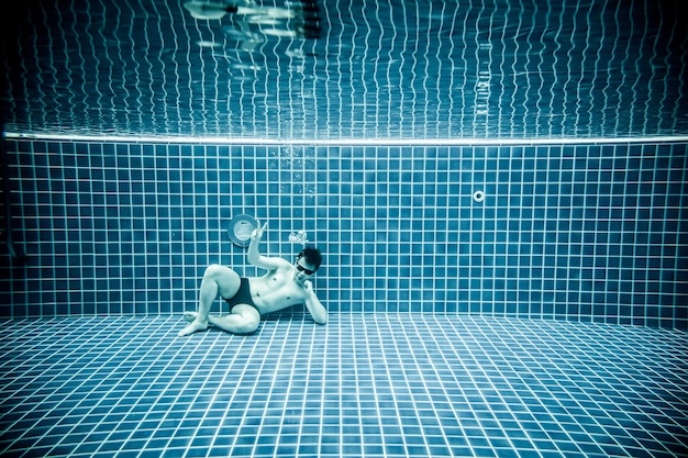 Las personas yace bajo el agua en una piscina