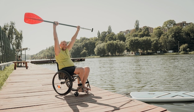 Personen mit einer körperlichen Behinderung, die einen Rollstuhl benutzen, werden auf dem SUP-Board mitfahren