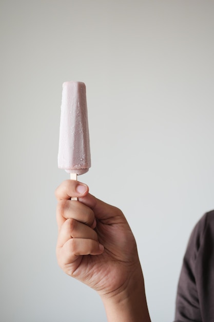 Personenhand, die Eiscreme mit Kopienraum hält