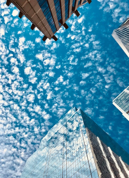 Foto perspectiva de bajo ángulo de los edificios contra un cielo nublado azul