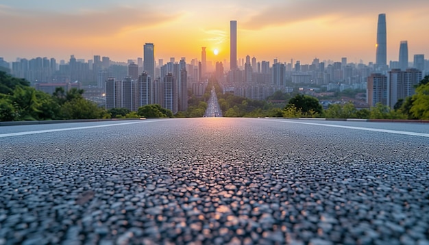 La perspectiva de la carretera contra el fondo de la puesta de sol y el paisaje urbano