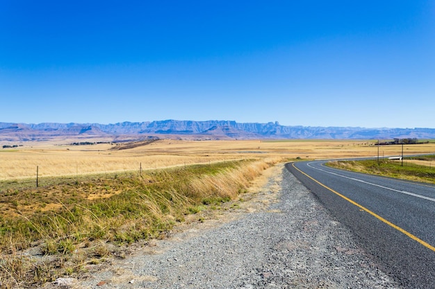 Perspectiva de la carretera desde Sudáfrica a lo largo de la carretera hacia las montañas del Dragón. Paisaje de Drakensberg. viajes y al aire libre