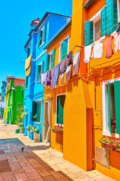 Perspectiva de rua com casas coloridas e roupas arejadas em Burano, Veneza, Itália