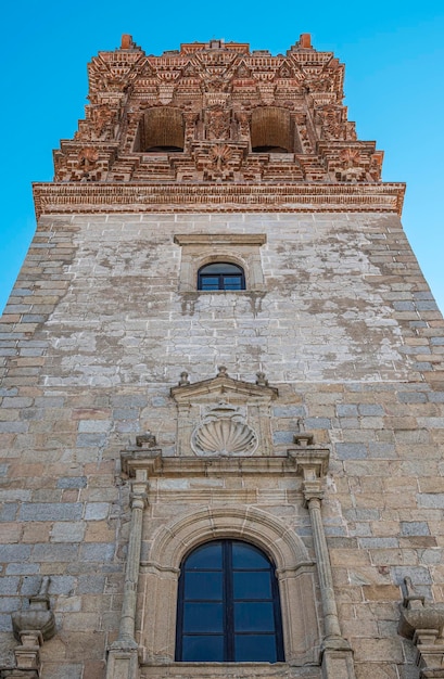 Foto perspectiva inferior do campanário de estilo barroco da igreja de san miguel arcangen na vila de jerez de los caballeros, espanha