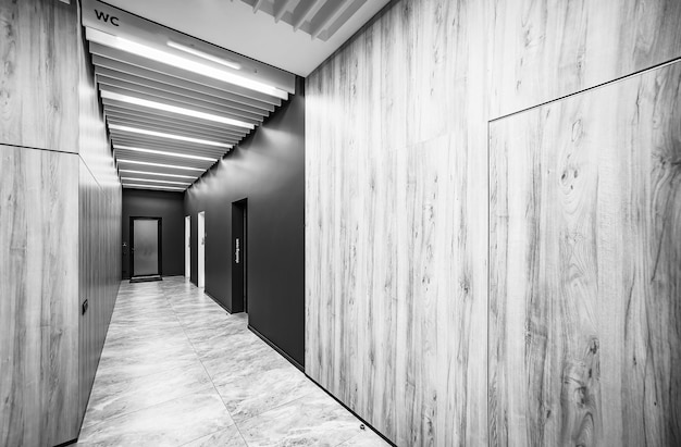 Perspectiva de un largo corredor en un edificio de oficinas Puertas de baños en el pasillo Puertas en la oficina con señales de baño Entrada a los baños en una fábrica