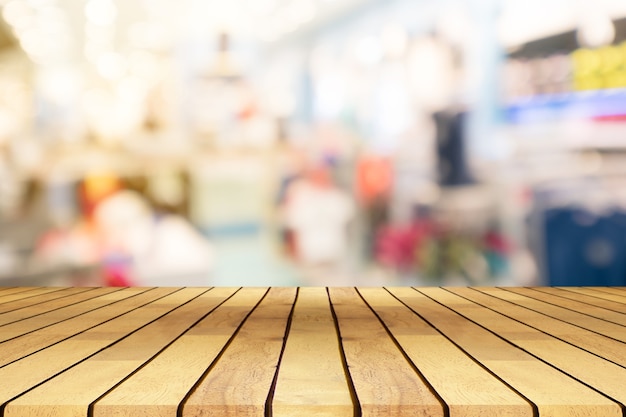 Foto perspectiva de mesa de madera vacía sobre fondo borroso centro comercial