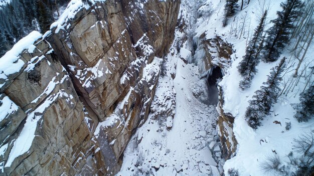 Una perspectiva de pájaro de un escarpado acantilado rocoso cubierto de nieve fresca con un camino de destrucción