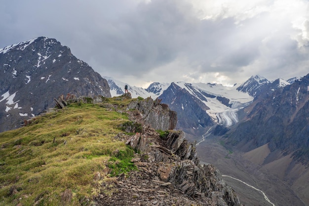 Perspektive des Felsvorsprungs. Rand der Klippe, eine gefährliche Schlucht. Fotojagd hoch in den Bergen. Fotograf mit großem Rucksack am Rand einer Klippe.