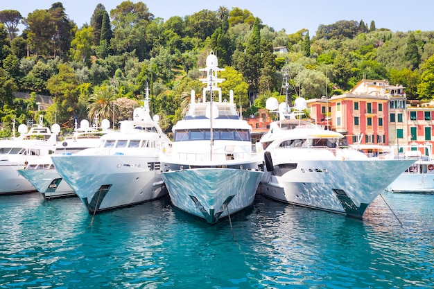 Perto da área de Cinque Terre, Portofino é uma das cidades mais bonitas e elegantes. Estes três iates estão localizados no porto de Portofino