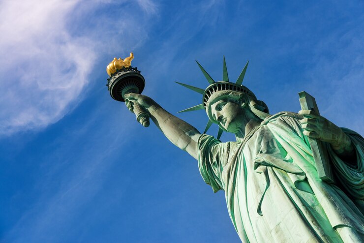 Foto perto da estátua da liberdade contra um céu azul nublado, cidade de nova york.