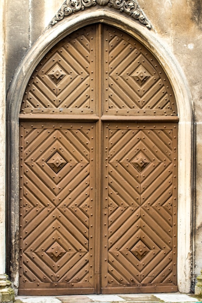 Perto da velha porta de madeira com decoração de metal.