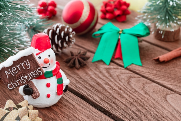 Perto de boneco de neve com sinal de feliz Natal e ornamets de Natal em madeira