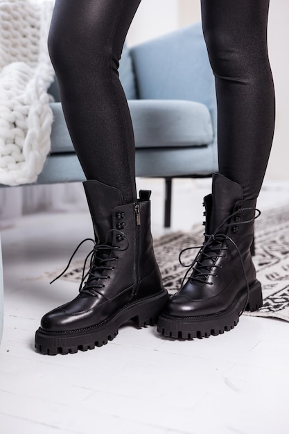 Perto de botas femininas negras. Botas de couro elegantes para mulheres na moda.