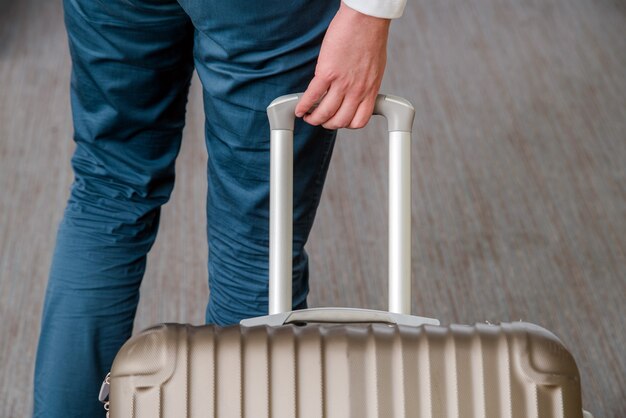 Perto de jovem homem de negócios com mala de bagagem no aeroporto