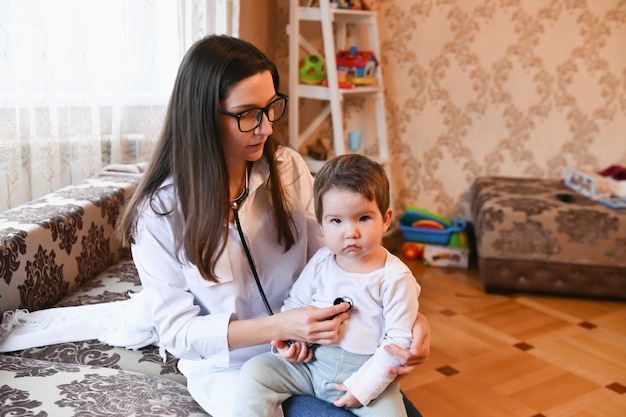 perto de médica com estetoscópio, ouvindo os batimentos cardíacos ou a respiração do paciente em casa