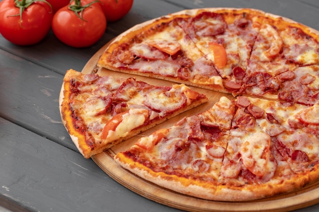 Perto de pizza recém-assada na mesa de madeira preta