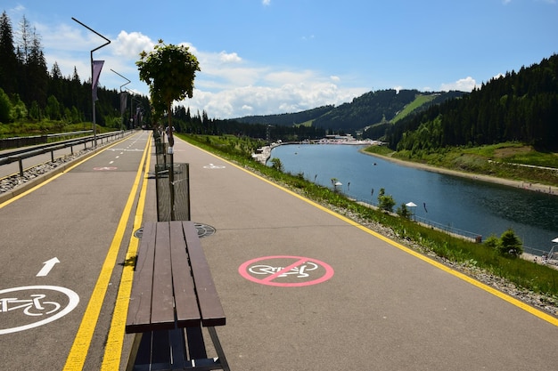Perto de um grande rio de montanha, há uma estrada de asfalto para bicicletas do resort com sinalização