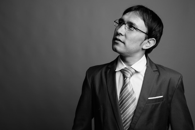 Perto de um jovem empresário asiático usando óculos