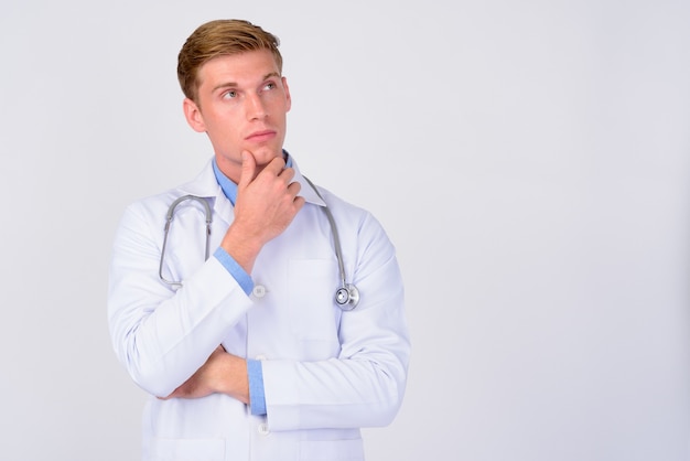 Perto de um médico jovem bonito com cabelo loiro isolado