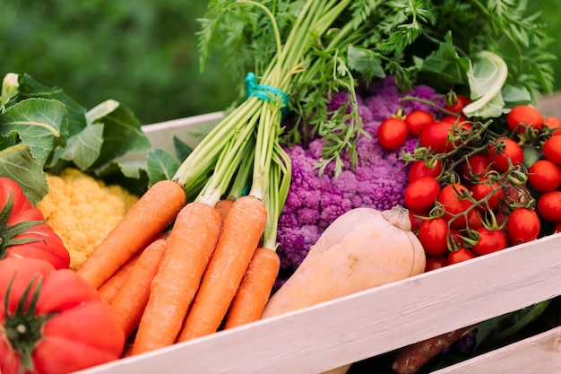 Perto de uma caixa cheia de vegetais e verduras