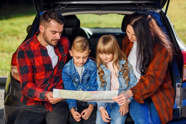 Perto de uma família agradável e alegre, que começa suas férias com crianças adolescentes e usa o roteiro para escolher o caminho certo no carro