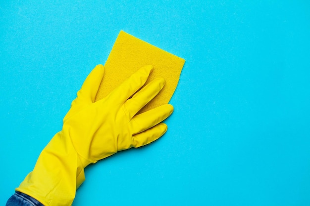 Perto de uma mulher com luvas amarelas segurando um pano de limpeza.