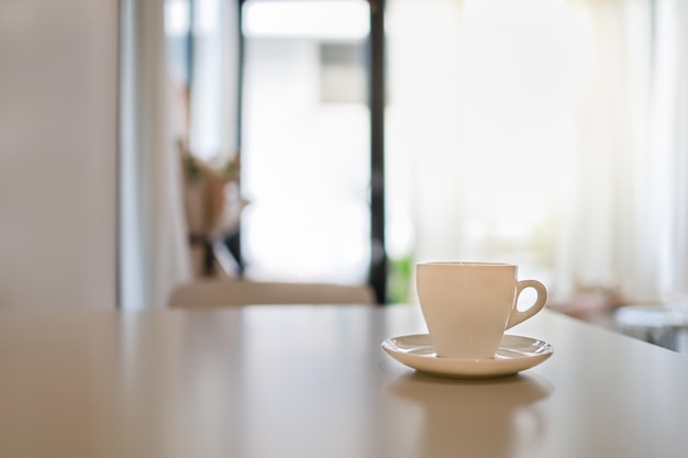 Perto de uma xícara de café quente com um prato na mesa em um restaurante