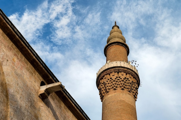 Foto perto do minarete da grande mesquita de bursa, com céu azul.