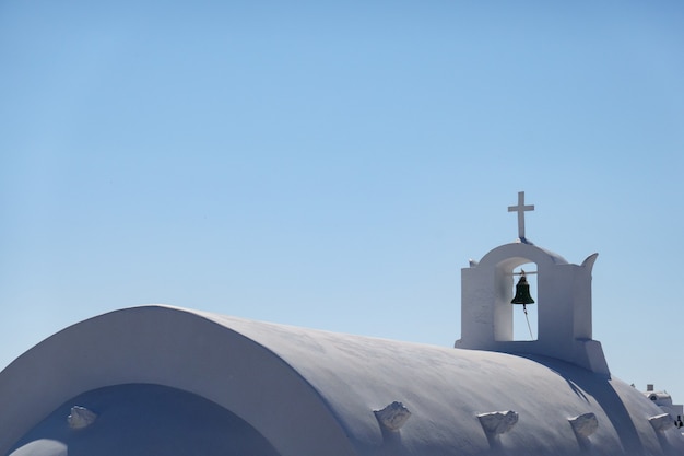 Perto do sino, igreja branca em oia santorini, grécia.