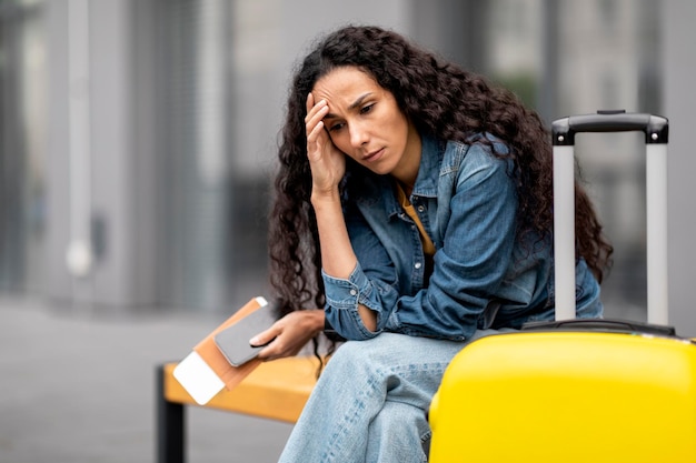 Foto perturbada jovem sentada no banco esperando seu voo