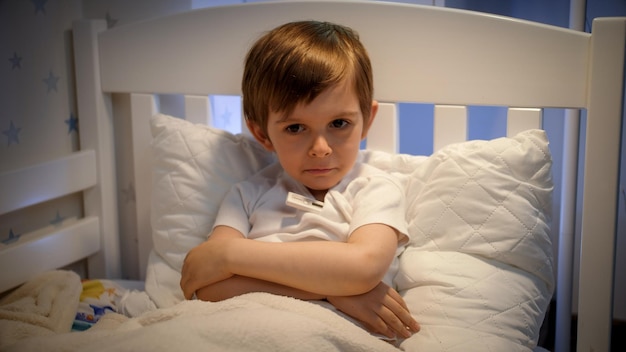 Foto perturbado, sentindo-se mal, tossindo e medindo a temperatura corporal conceito de doença infantil