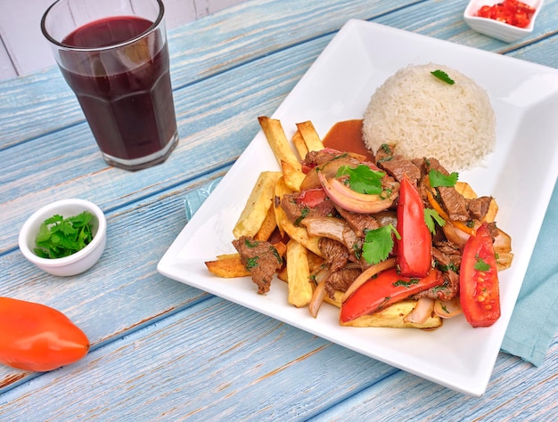 Peruanisches Essen Lomo saltado Gesuchtes Rindfleisch mit Tomaten, Zwiebeln, gebratenen Kartoffeln und Reis