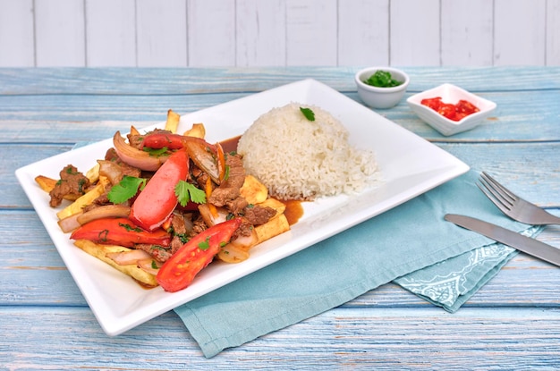 Peruanisches Essen Lomo saltado Gesuchtes Rindfleisch mit Tomaten, Zwiebeln, gebratenen Kartoffeln und Reis