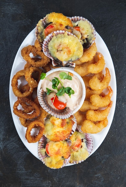 Peruanisches Essen Piqueo Caliente, heiße Meeresfrüchteplatte, gebratene Garnelen, Tintenfischringe und gebackene Jakobsmuscheln mit