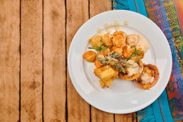 Peruanisches Essen Sautierte Garnelen mit Kräutern und Knoblauch auf einem Holztisch serviert auf einem weißen Teller